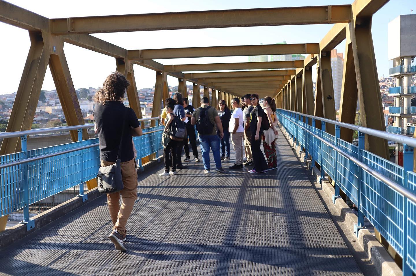 pessoas andando em cima de ponte na zona leste