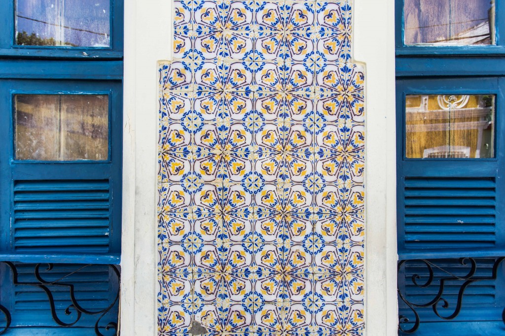 fachada de azulejos coloridos entre duas janelas azuis em Olinda
