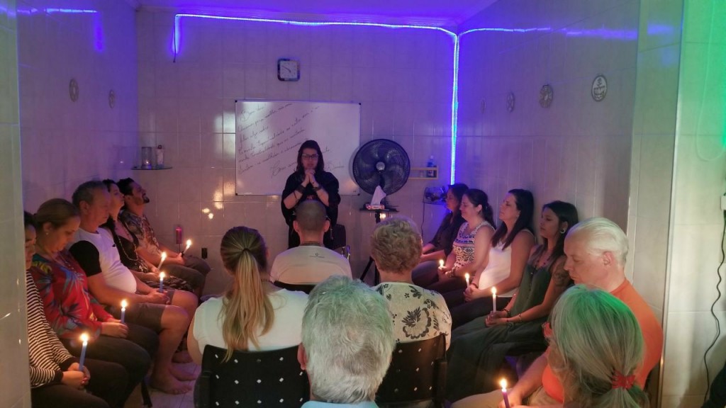 benzedeiras ministram curso para alunos numa sala com luzes azuis 