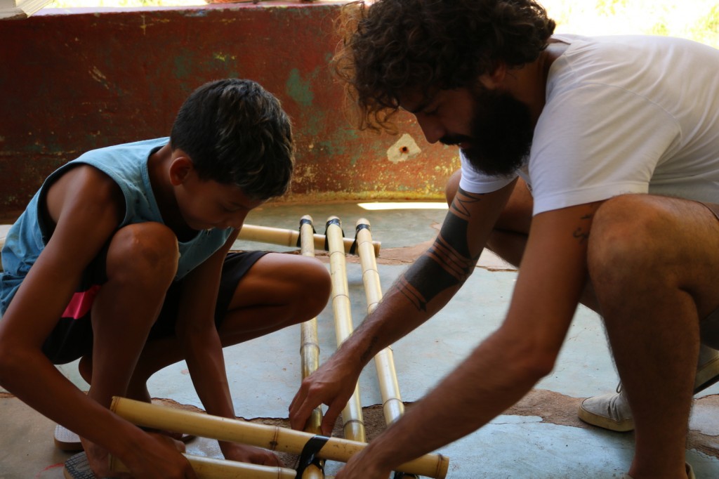 rapaz e criança trabalham com a estrutura de bambui