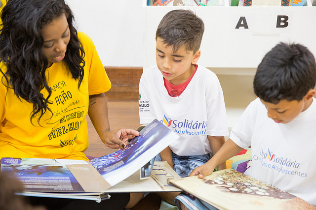 voluntária lê para duas crianças na liga solidária 
