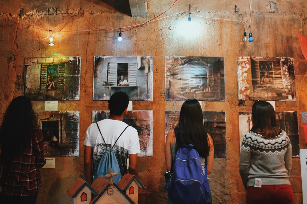 jovens olham exposição no museu social muquifu