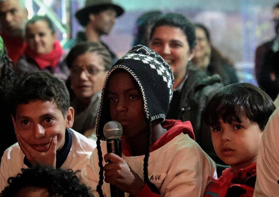 criança fala no microfone na feira literária